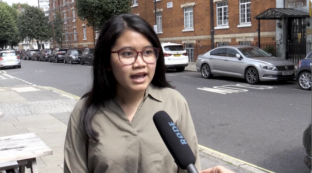 Woman talking into a microphone on the street