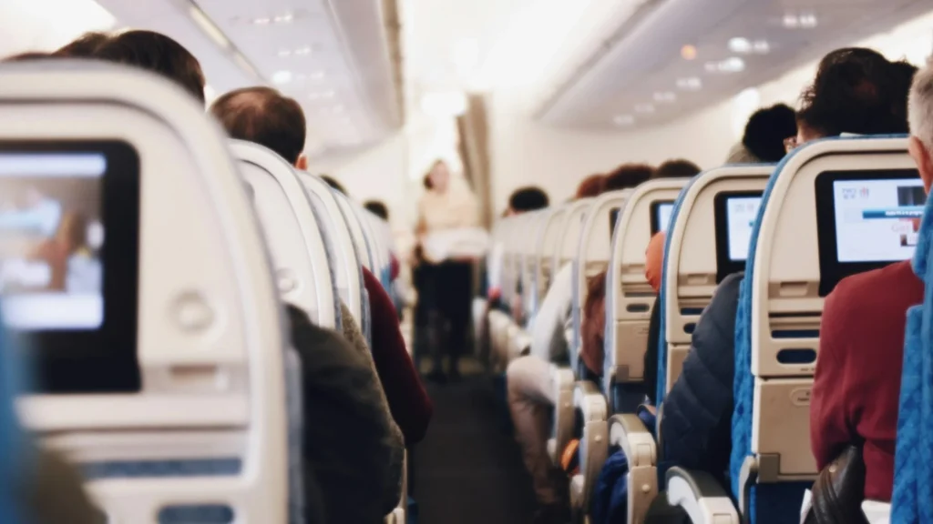 Airplane aisle with rows of seats on both sides.