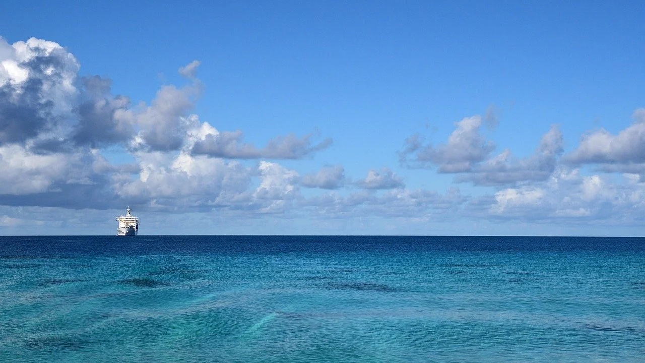 Beautiful summer's day at sea with deep turquoise blue waters and a white ship on the horizon Beautiful summer's day at sea with deep turquoise blue waters and a white ship on the horizon