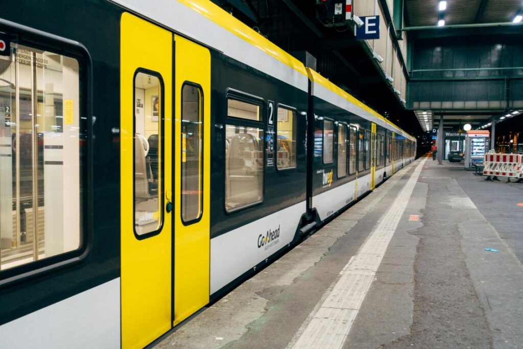 A modern yellow and blue train pulled up at a railway station