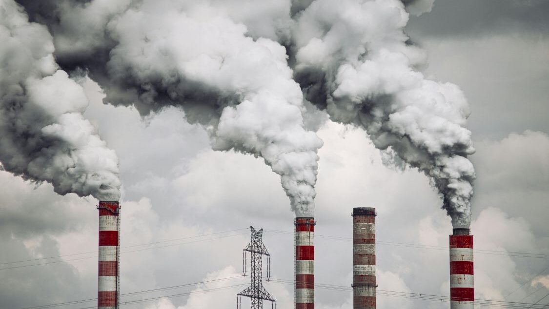 Red and white striped chimneys releasing thick white smoke into the air