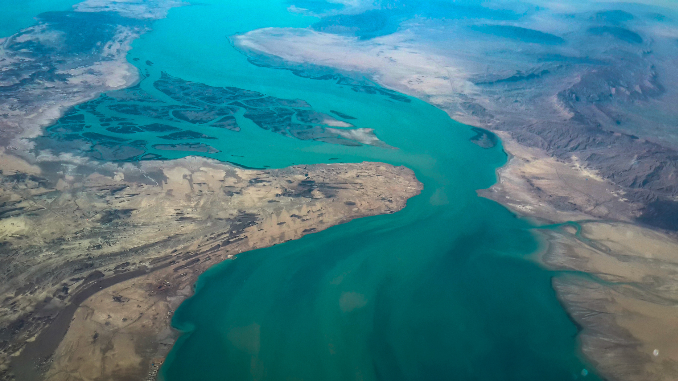 Birds eye view of turquoise ocean and coastal land