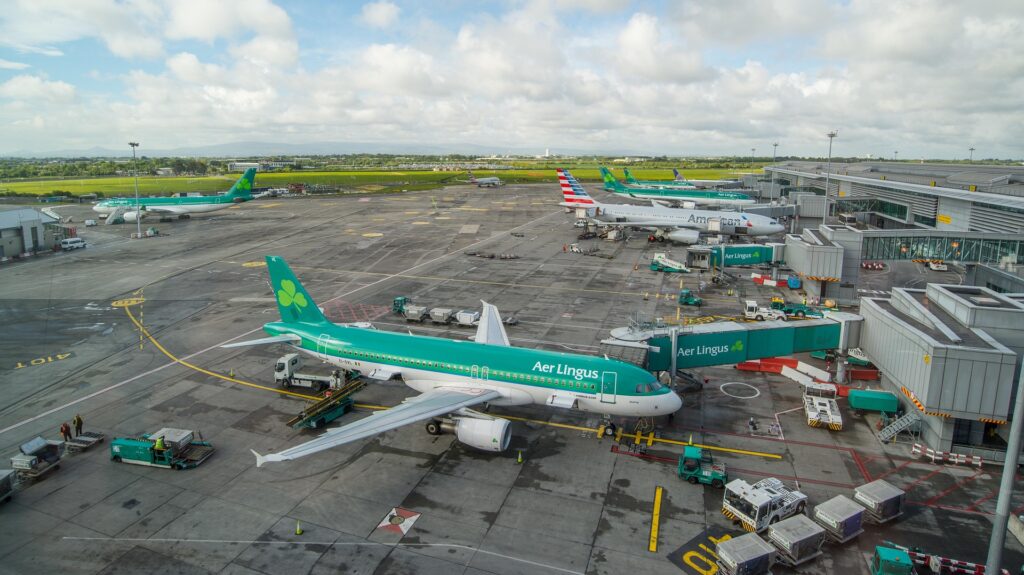 A busy airport terminal featuring Aer Lingus planes