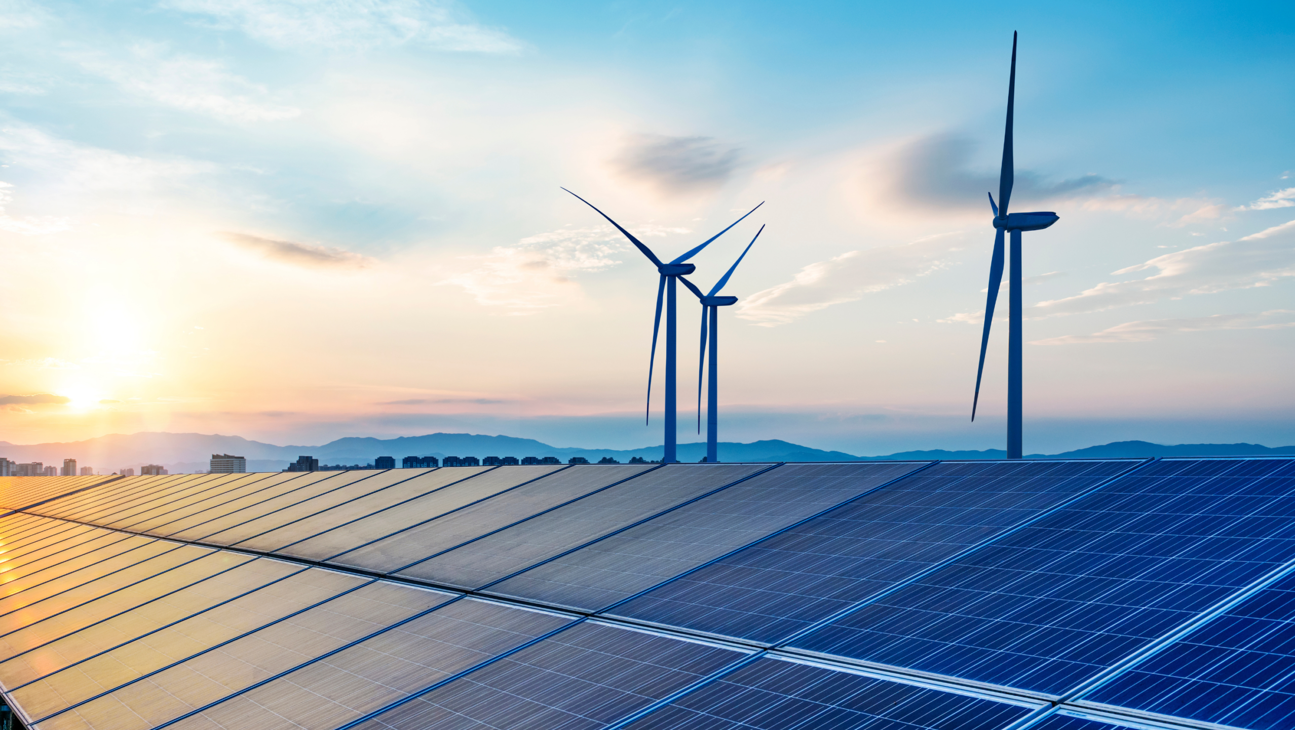Solar panels and wind turbines against blue sky
