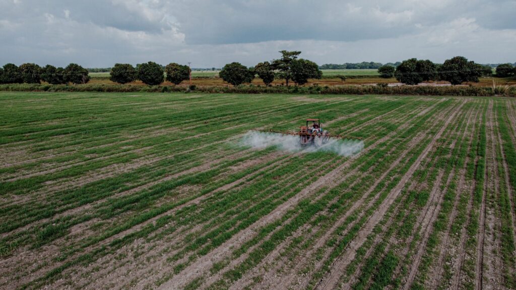 Tractor spraying a large commercial crop on an overcast day