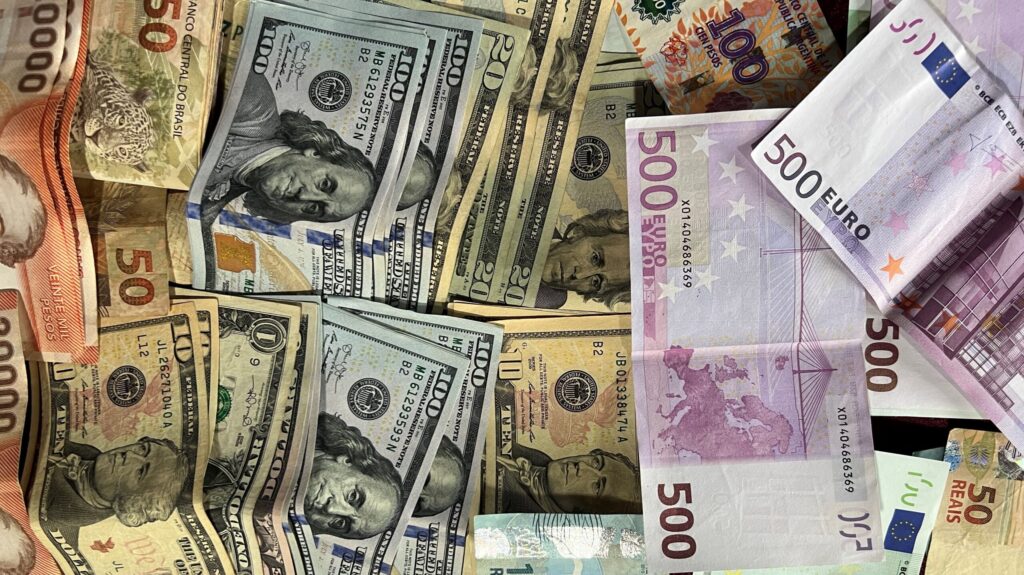 A layout of different banknotes from various countries including US dollars and Euros