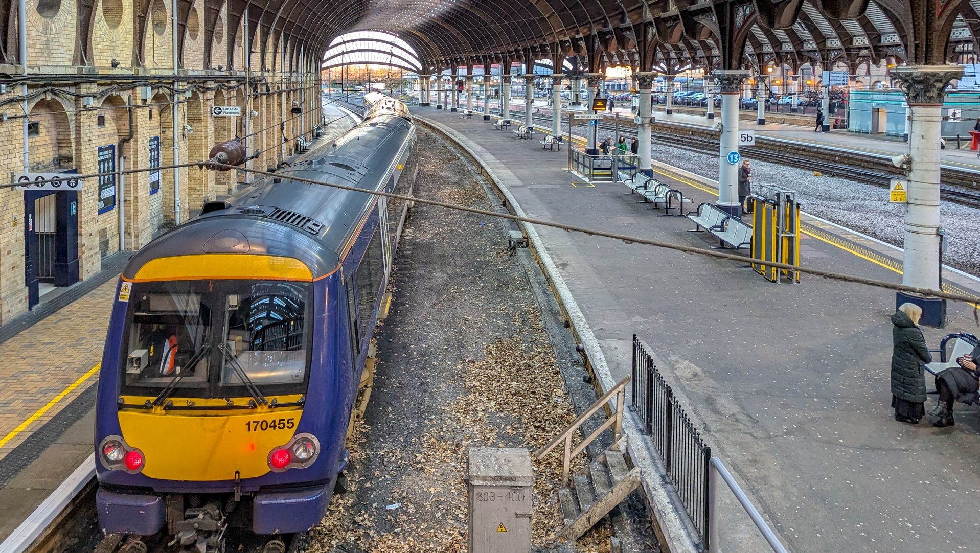 UK train station with train waiting at platform