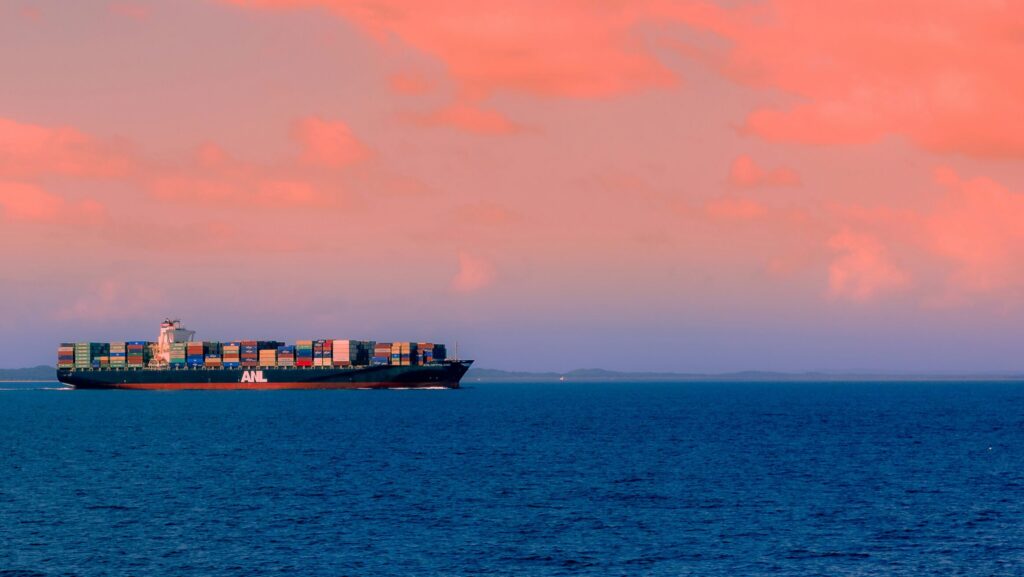 Cargo ship moving through the sea at dusk